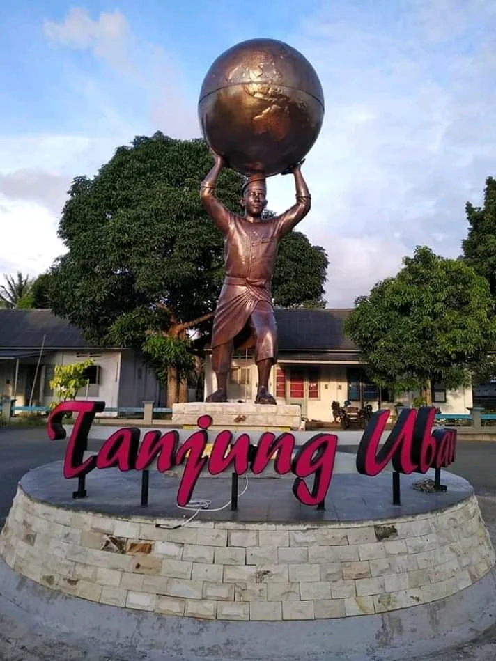Patung yang mengangkat bola dunia dengan tulisan Tanjung Uban pada bangunan alasnya